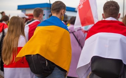 A group of protesters holding Ukrainian and Belorusian white and red flag