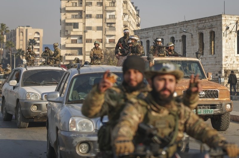 Syrian opposition fighters ride along the streets in the aftermath of the opposition's takeover of Hama, Syria, Friday, Dec. 6, 2024. 