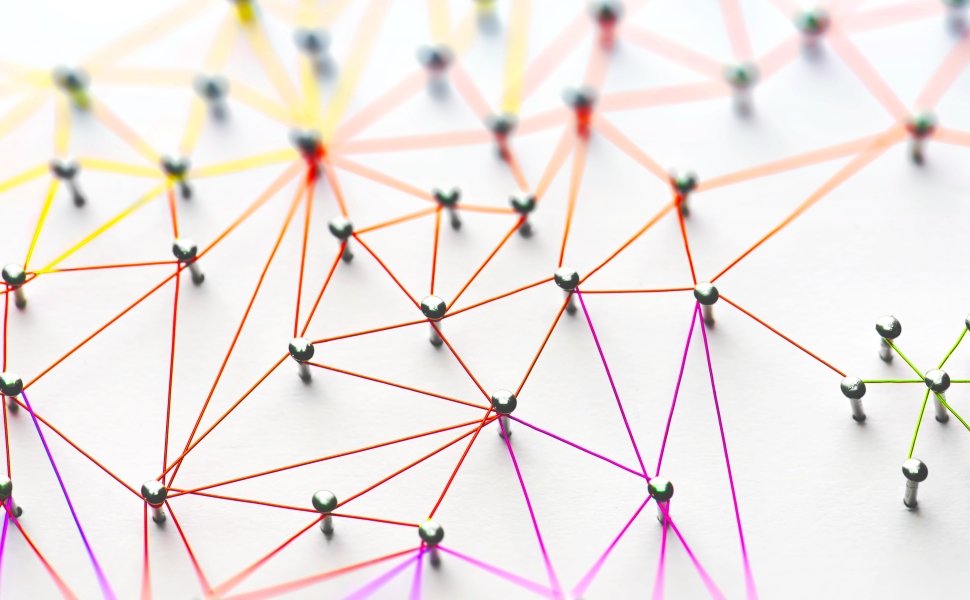 Linking entities. Networking, social media, SNS, internet communication abstract. Small network connected to a larger network. Web of red, orange and yellow wires on white background.